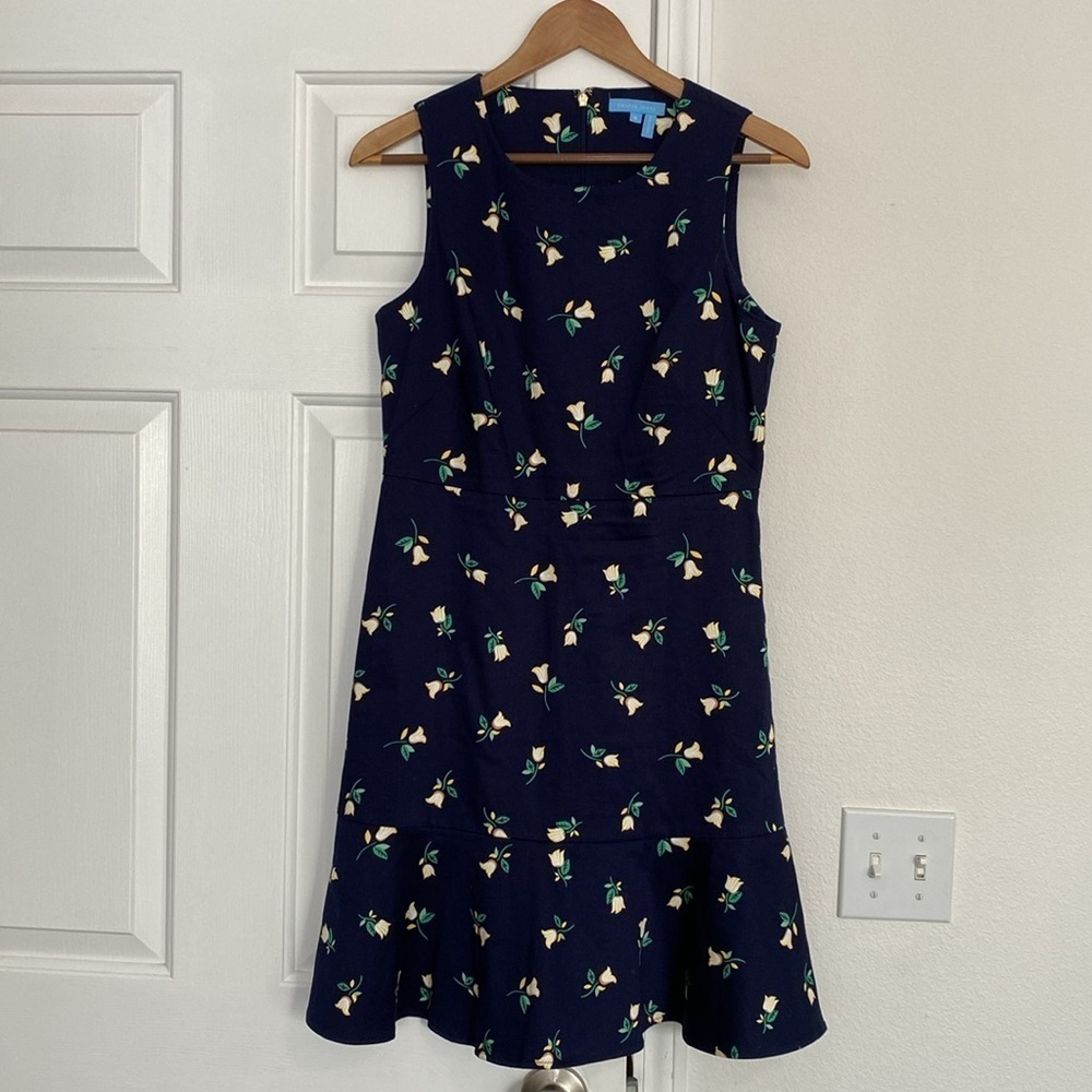 Draper James navy floral sleeveless dress with ruffled hem.
